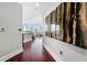 Inviting hallway with a hardwood floor, wall decor, and a view of the well lit living area, leading to the main living spaces at 1080 Peachtree Ne St # 2710, Atlanta, GA 30309