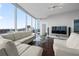 Cozy living room with large windows offering city views, a plush white sofa set, and hardwood floors, ideal for relaxation at 1080 Peachtree Ne St # 2710, Atlanta, GA 30309