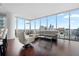 Bright living room featuring a wraparound window, hardwood floors, and a comfortable sectional sofa with beautiful city views at 1080 Peachtree Ne St # 2710, Atlanta, GA 30309