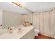 Well-lit bathroom with a spacious vanity, large mirror, and a classic shower curtain at 4045 Boles Creek Dr, Duluth, GA 30096