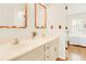 Bathroom featuring double sinks, copper-trimmed mirrors, and a view to the connected bedroom at 4045 Boles Creek Dr, Duluth, GA 30096
