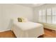 Well-lit bedroom with a window seat, wood floors, and classic white bedding at 4045 Boles Creek Dr, Duluth, GA 30096