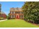 Charming two-story brick home with a well-manicured lawn, red door, and classic design at 4045 Boles Creek Dr, Duluth, GA 30096