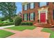 Close up of the entryway featuring a red door and brick walkway surrounded by greenery at 4045 Boles Creek Dr, Duluth, GA 30096
