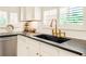 Close-up of kitchen features granite countertops, white cabinetry, and stainless steel faucet at 4045 Boles Creek Dr, Duluth, GA 30096