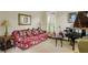 Cozy living room featuring a floral sofa, grand piano, and natural light from the window at 4045 Boles Creek Dr, Duluth, GA 30096