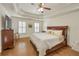 Tranquil main bedroom with tray ceiling, hardwood floors, and shuttered windows at 4045 Boles Creek Dr, Duluth, GA 30096