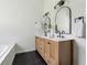 Elegant bathroom featuring double sinks, wood cabinets, and modern fixtures at 4369 Milford Pl, Hoschton, GA 30548