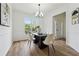 Elegant dining room with natural light, featuring modern decor, hardwood floors, and an open view to the home's entry at 4369 Milford Pl, Hoschton, GA 30548