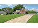 An eye-level side-view of an attractive home with a well-kept lawn and long driveway at 4369 Milford Pl, Hoschton, GA 30548