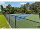 Tennis courts surrounded by a fence and mature trees, providing a private and secure area for sports at 4369 Milford Pl, Hoschton, GA 30548