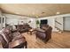 Finished basement with dark leather seating, a large tv, and vinyl plank flooring at 1630 Reindeer Rdg, Alpharetta, GA 30005