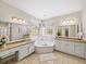 Bright bathroom featuring tub, granite counters, dual sinks, and a vanity with ample storage at 1630 Reindeer Rdg, Alpharetta, GA 30005