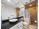Well-lit bathroom featuring a vessel sink, black countertop, and a shower with tile surround and glass door at 1630 Reindeer Rdg, Alpharetta, GA 30005
