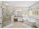 Bright bathroom featuring marble shower, soaking tub, granite counters, and vanity with ample storage at 1630 Reindeer Rdg, Alpharetta, GA 30005