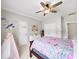 Bright bedroom featuring a ceiling fan, light gray walls, white trim, and a bed with colorful coverings at 1630 Reindeer Rdg, Alpharetta, GA 30005