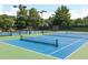 Well-maintained blue tennis courts surrounded by mature trees, ideal for recreational play at 1630 Reindeer Rdg, Alpharetta, GA 30005