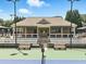 View of a tennis court and clubhouse with shaded seating for spectators at 1630 Reindeer Rdg, Alpharetta, GA 30005