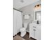 Bathroom features a shower with a white curtain, modern vanity with a black faucet, and wood-look flooring at 5990 Eagle Tiff Ln, Sugar Hill, GA 30518