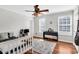 Bright bedroom with a ceiling fan, hardwood floors, and a keyboard next to bright, natural lighting at 5990 Eagle Tiff Ln, Sugar Hill, GA 30518