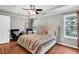Inviting bedroom with tray ceiling, neutral walls, wood floors, and comfortable seating at 5990 Eagle Tiff Ln, Sugar Hill, GA 30518