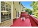 Exterior view of a private deck with red-painted floors and a tan-colored home at 5990 Eagle Tiff Ln, Sugar Hill, GA 30518