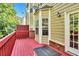 Exterior view of a private deck with red-painted floors with a view of the yard and neighborhood at 5990 Eagle Tiff Ln, Sugar Hill, GA 30518