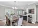 Bright dining area featuring a stylish table, modern lighting, and seamless access to the kitchen and outdoor patio at 5990 Eagle Tiff Ln, Sugar Hill, GA 30518