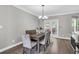 Elegant dining room with a modern chandelier, stylish chairs, and access to the outdoor patio at 5990 Eagle Tiff Ln, Sugar Hill, GA 30518