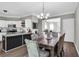 Open-concept kitchen featuring white cabinets, subway tile backsplash, and a dining area with a wooden table at 5990 Eagle Tiff Ln, Sugar Hill, GA 30518