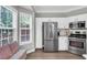 Bright kitchen with stainless steel appliances, white cabinetry, and a bay window at 5990 Eagle Tiff Ln, Sugar Hill, GA 30518