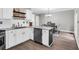 Modern kitchen with white cabinets, stainless steel appliances, granite countertops, and wood flooring at 5990 Eagle Tiff Ln, Sugar Hill, GA 30518