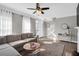 Bright living room featuring a comfortable sofa, large windows with sheer curtains, and modern decor at 5990 Eagle Tiff Ln, Sugar Hill, GA 30518