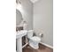 Chic powder room featuring a pedestal sink, stylish faucet, and decorative mirror at 5990 Eagle Tiff Ln, Sugar Hill, GA 30518