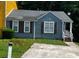 Charming blue home with a well-maintained lawn and a paved driveway at 6470 Bedford Ln, Lithonia, GA 30058