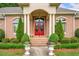 Inviting front entrance with a vibrant red door, surrounded by green landscaping and decorative urns at 226 Euharlee Five Forks Rd, Kingston, GA 30145
