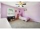 Comfortable purple bedroom with a decorative canopy, soft carpet, and a bright window at 325 Stonecastle Sw Pass, Atlanta, GA 30331