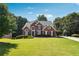 Brick home with an immaculate lawn, mature trees, and a basketball hoop in the driveway at 325 Stonecastle Sw Pass, Atlanta, GA 30331