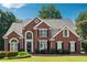 Stately two-story brick home boasts manicured landscaping, charming black shutters, and a welcoming front entrance at 325 Stonecastle Sw Pass, Atlanta, GA 30331