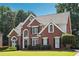 Charming two-story brick home with landscaped yard, manicured shrubbery, and welcoming front entrance on a sunny day at 325 Stonecastle Sw Pass, Atlanta, GA 30331