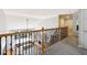 Bright, carpeted second floor hallway offers a view into the main floor living room at 325 Stonecastle Sw Pass, Atlanta, GA 30331