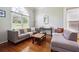 Bright living room features hardwood floors, two sofas, large windows, and a cozy, inviting atmosphere at 325 Stonecastle Sw Pass, Atlanta, GA 30331