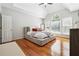 Light-filled primary bedroom featuring hardwood floors, large windows, and ceiling fan at 325 Stonecastle Sw Pass, Atlanta, GA 30331