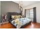 Comfortable bedroom with textured accent wall, unique lighting, hardwood floors, and a large window at 196 Mystic Ct, Atlanta, GA 30342