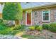 Inviting brick home entrance with landscaped garden and red door with glass, enhanced with a Ring doorbell at 3440 Ashwood Ln, Atlanta, GA 30341