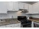 Well-lit kitchenette features clean white cabinetry, stainless appliances, and granite countertop space at 836 Saint Charles Ne Ave # I, Atlanta, GA 30306