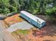 Aerial view of home shows treed lot, gravel driveway, and well maintained lawn at 4820 Scott Rd, Cumming, GA 30041
