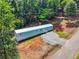 Aerial view of a single story home, treed property, long driveway, and gravel parking area at 4820 Scott Rd, Cumming, GA 30041