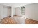 Bright bedroom features a window overlooking the wooded property and gleaming wood-look floors at 4820 Scott Rd, Cumming, GA 30041