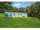 Exterior angle view shows a single story home with grass yard and surrounding trees at 4820 Scott Rd, Cumming, GA 30041